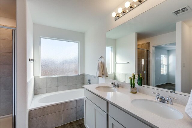 bathroom featuring hardwood / wood-style floors, vanity, and separate shower and tub