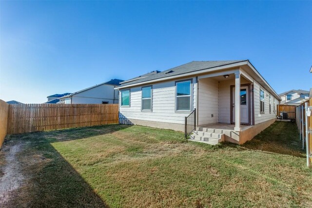 rear view of property featuring a yard