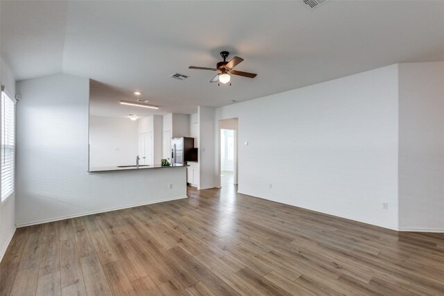 unfurnished living room featuring ceiling fan, light hardwood / wood-style flooring, lofted ceiling, and sink