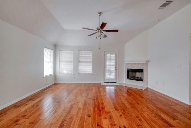 unfurnished living room with visible vents, ceiling fan, light wood-type flooring, baseboards, and a tile fireplace