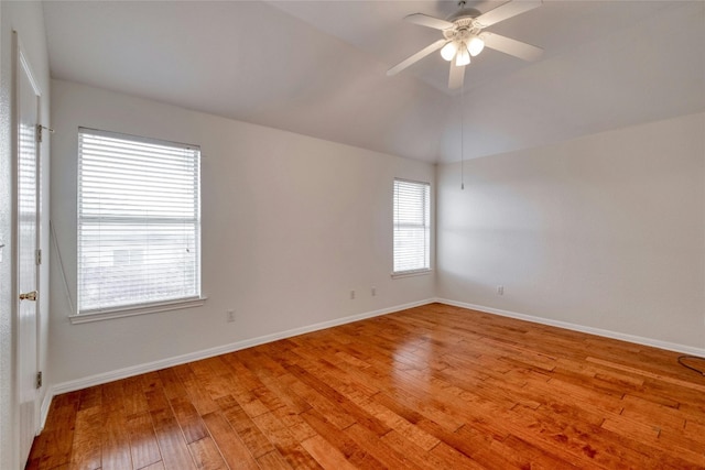 unfurnished room featuring a ceiling fan, lofted ceiling, baseboards, and light wood finished floors