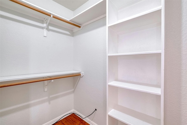 walk in closet with wood finished floors