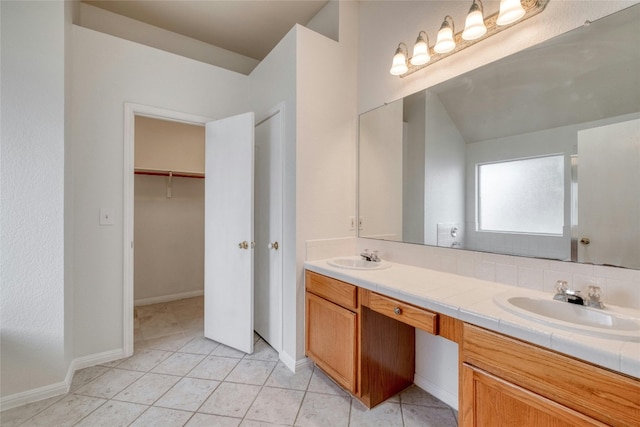 bathroom with tile patterned floors, a sink, and double vanity