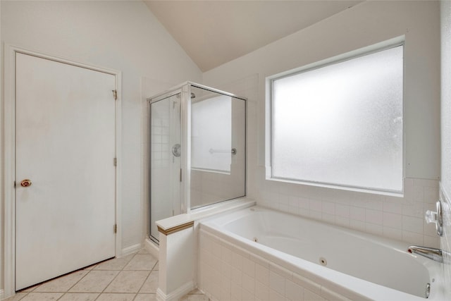 bathroom featuring a stall shower, vaulted ceiling, a tub with jets, and tile patterned floors