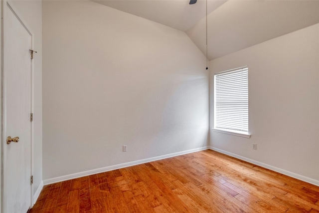 empty room with lofted ceiling, baseboards, and light wood finished floors