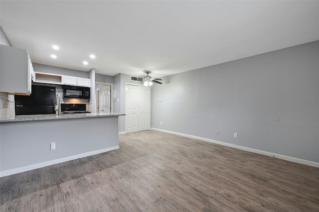 kitchen with light stone countertops, decorative backsplash, white cabinetry, and black appliances