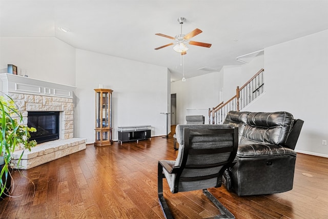 living room featuring ceiling fan, wood-type flooring, a fireplace, and vaulted ceiling