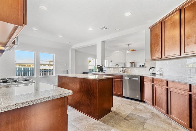 kitchen with a center island, lofted ceiling, stainless steel appliances, and a wealth of natural light