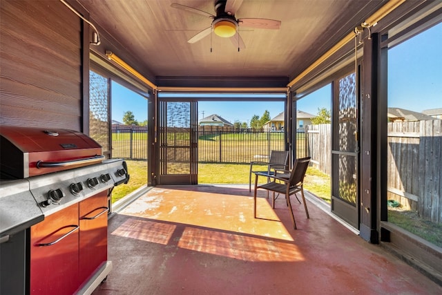 sunroom / solarium featuring wooden ceiling, ceiling fan, and a healthy amount of sunlight