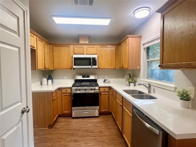 kitchen featuring stainless steel appliances, light hardwood / wood-style flooring, and sink