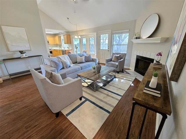 living room with vaulted ceiling and a tile fireplace