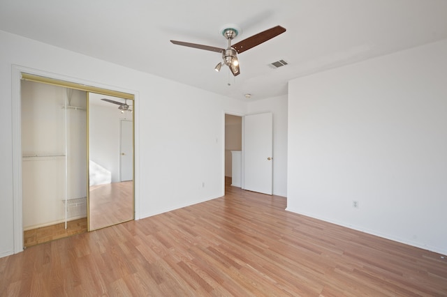 unfurnished bedroom featuring ceiling fan, a closet, and light hardwood / wood-style floors