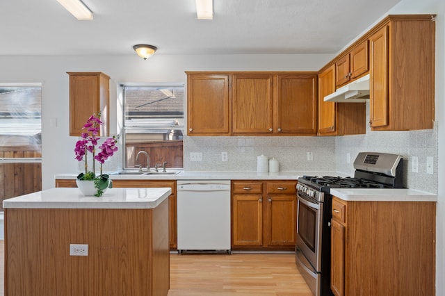 kitchen featuring sink, gas range, dishwasher, light hardwood / wood-style flooring, and a center island