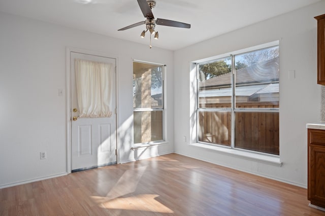 unfurnished dining area with ceiling fan and light hardwood / wood-style floors