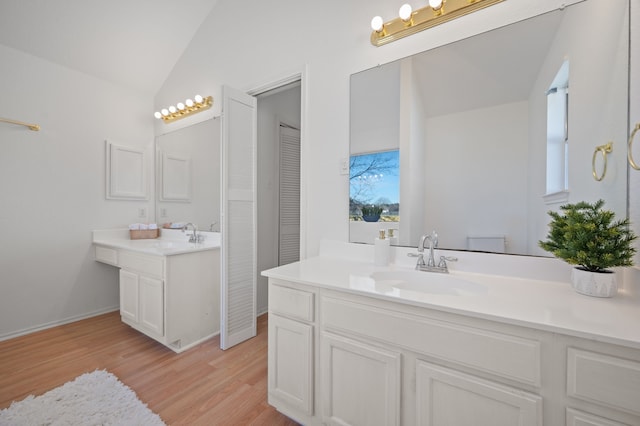 bathroom with lofted ceiling, vanity, and hardwood / wood-style flooring