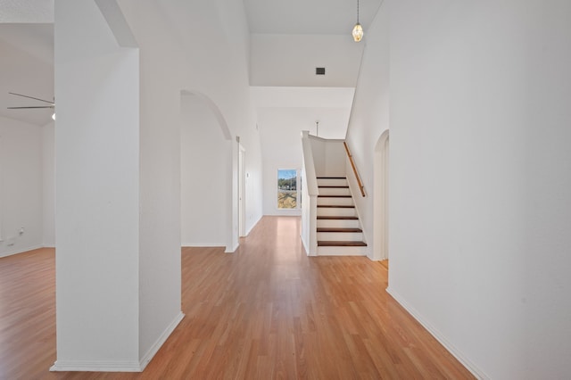 hallway featuring light hardwood / wood-style floors and a high ceiling