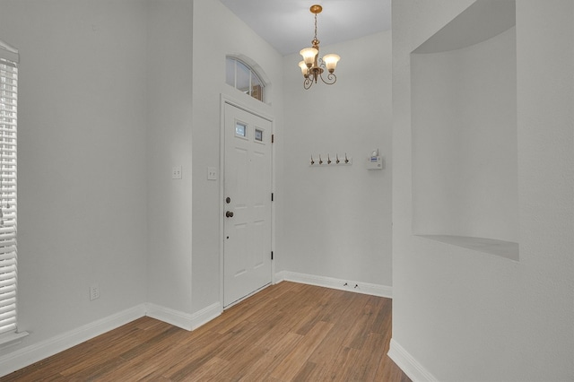 foyer entrance featuring hardwood / wood-style floors and a notable chandelier