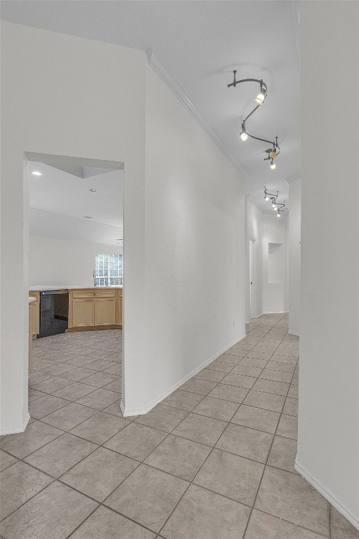 corridor featuring crown molding and light tile patterned floors