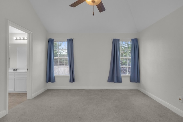 spare room with light colored carpet, vaulted ceiling, and a wealth of natural light