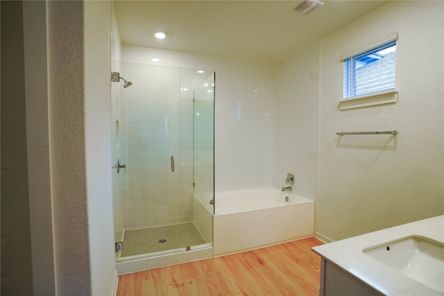 bathroom featuring hardwood / wood-style flooring, vanity, and independent shower and bath