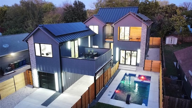 back of house with a balcony and a fenced in pool