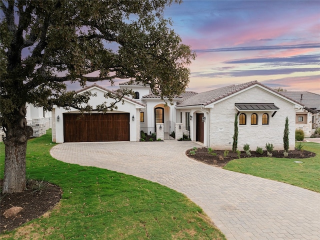 mediterranean / spanish-style house with a garage and a yard