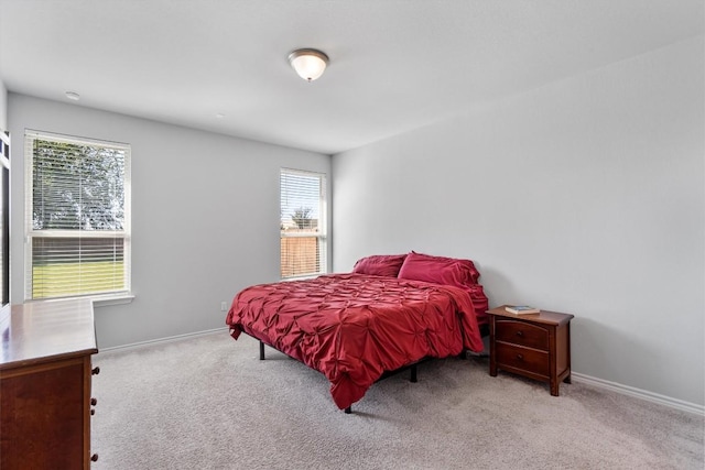 bedroom with light carpet and multiple windows