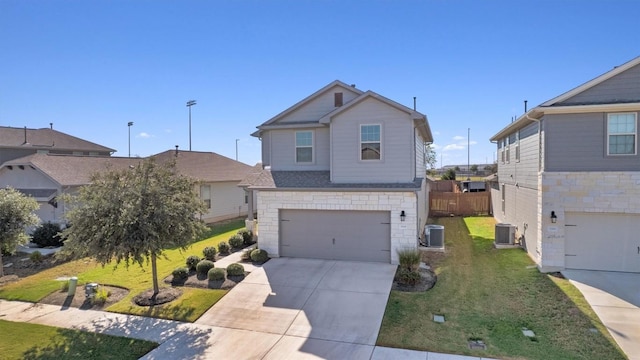 view of front of house featuring central AC unit, a garage, and a front lawn