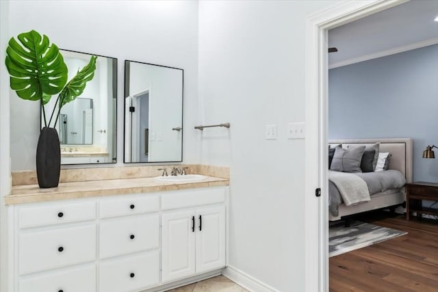 bathroom featuring hardwood / wood-style flooring, vanity, and crown molding