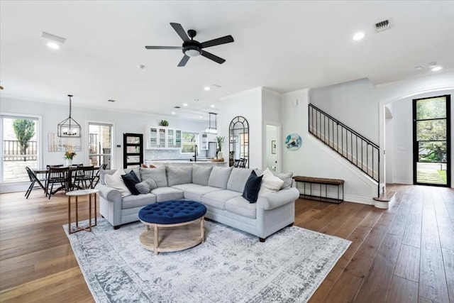 living room featuring ornamental molding, dark hardwood / wood-style floors, ceiling fan, and a healthy amount of sunlight