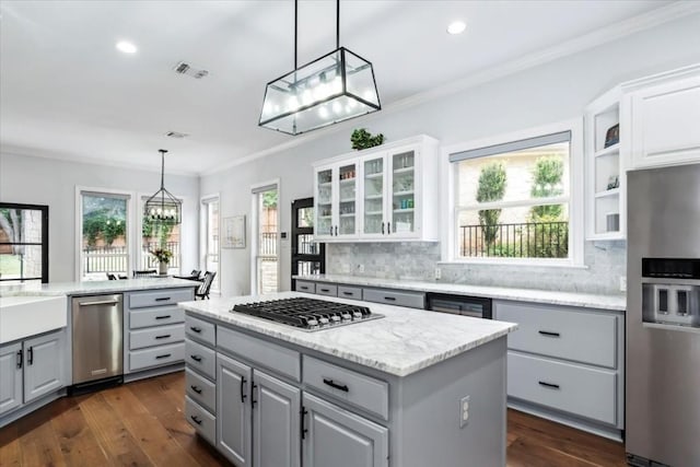 kitchen with dark hardwood / wood-style flooring, backsplash, stainless steel appliances, pendant lighting, and gray cabinets