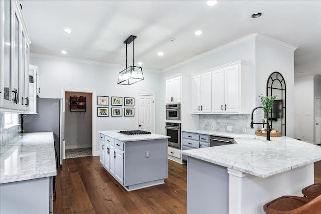 kitchen featuring dark hardwood / wood-style floors, a kitchen island, white cabinetry, and hanging light fixtures