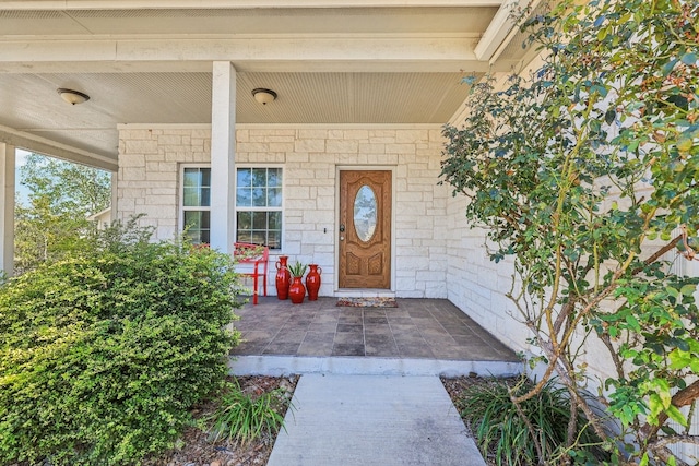 view of exterior entry featuring covered porch