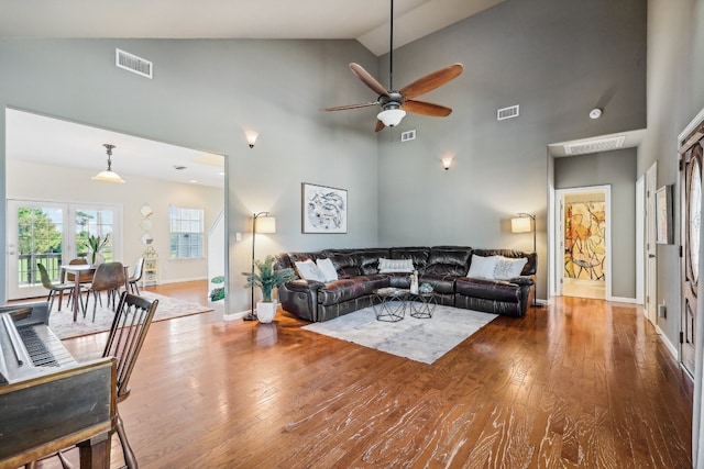 living room with ceiling fan, high vaulted ceiling, and hardwood / wood-style flooring