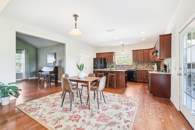 dining area featuring dark hardwood / wood-style flooring, sink, and vaulted ceiling