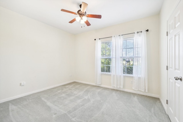 spare room featuring light colored carpet and ceiling fan