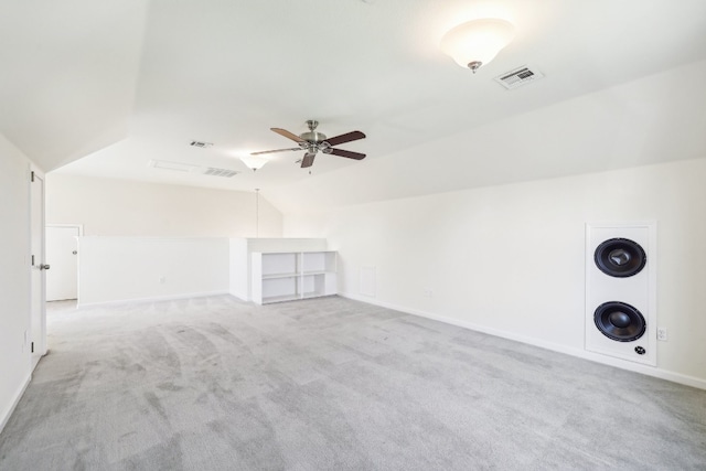 carpeted spare room featuring ceiling fan and vaulted ceiling