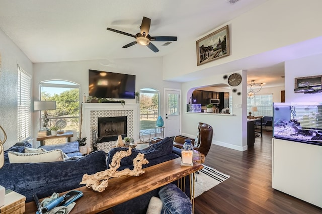 living room featuring a wealth of natural light, a fireplace, dark wood-type flooring, and lofted ceiling