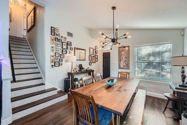 dining area featuring dark hardwood / wood-style flooring, an inviting chandelier, and vaulted ceiling