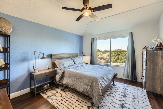 bedroom with vaulted ceiling, ceiling fan, and dark wood-type flooring