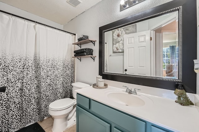 bathroom with tile patterned floors, vanity, toilet, and a textured ceiling