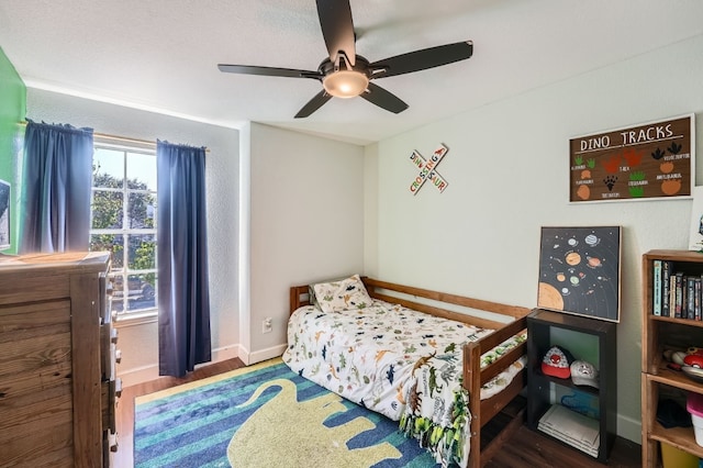 bedroom with dark hardwood / wood-style flooring and ceiling fan