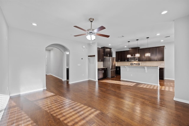 unfurnished living room with dark hardwood / wood-style floors and ceiling fan