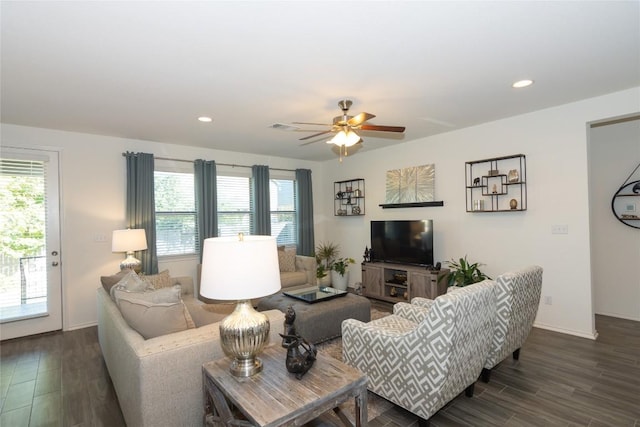 living room featuring ceiling fan, dark wood-type flooring, and a wealth of natural light