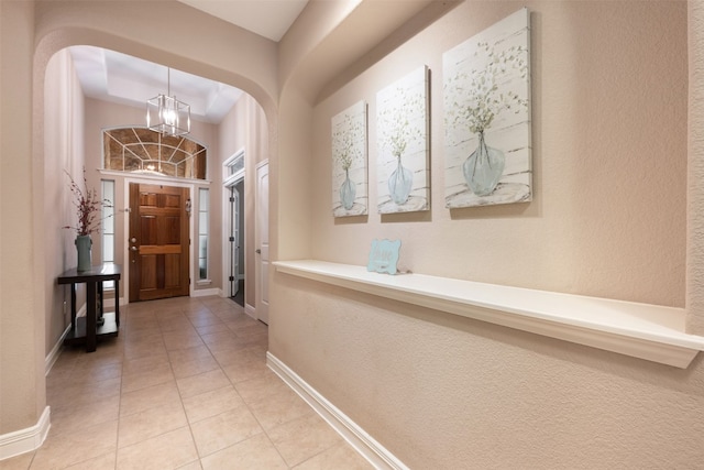 corridor with a chandelier and tile patterned floors