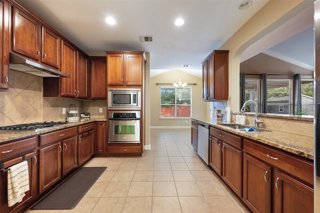 kitchen featuring tasteful backsplash, light stone countertops, sink, and stainless steel appliances