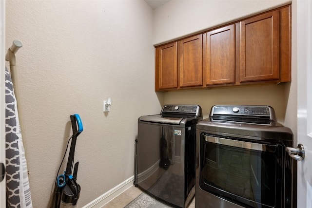 washroom with cabinets and washer and dryer