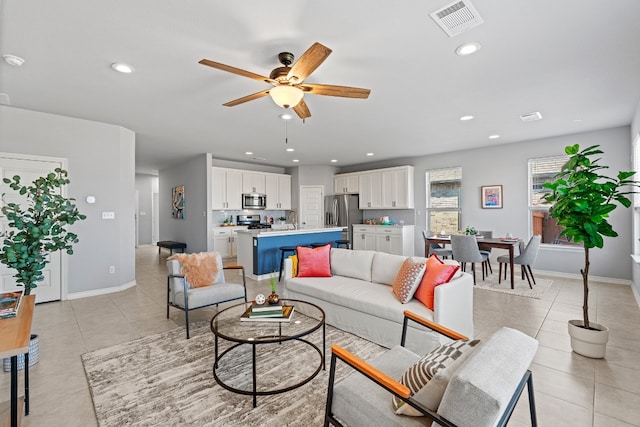 tiled living room featuring ceiling fan and sink