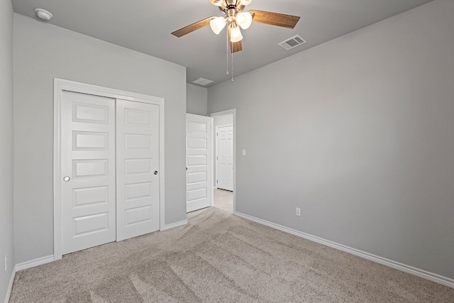 unfurnished bedroom featuring ceiling fan, a closet, and light carpet