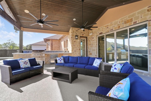 view of patio / terrace featuring an outdoor hangout area, ceiling fan, exterior kitchen, grilling area, and a mountain view